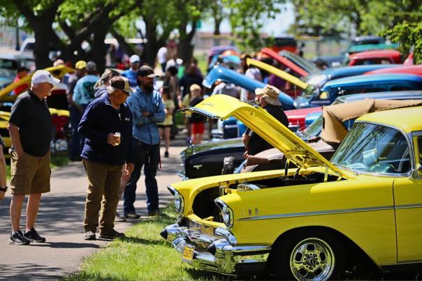 People admiring muscle cards at the Devils Run event in Devisl Lake, ND.