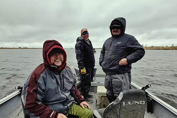 Three friends fishing in a boat on Devils Lake, ND.