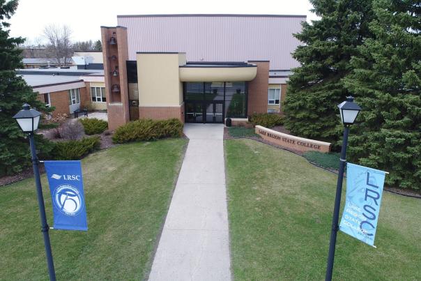 A front enterance to a building with blue banners on either side celebrating Lake Region State College (better known as LRSC)