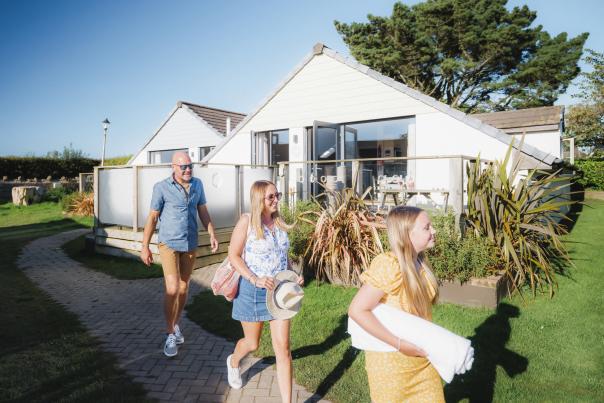 family outside lodge in Holiday Park in summer walking