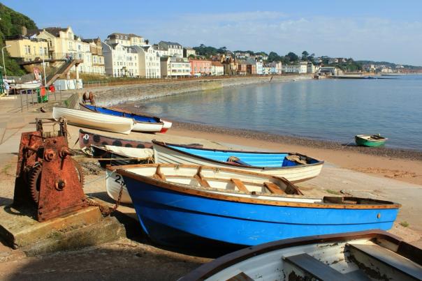 Image shows a selection of boats on a sandy beach in Devon