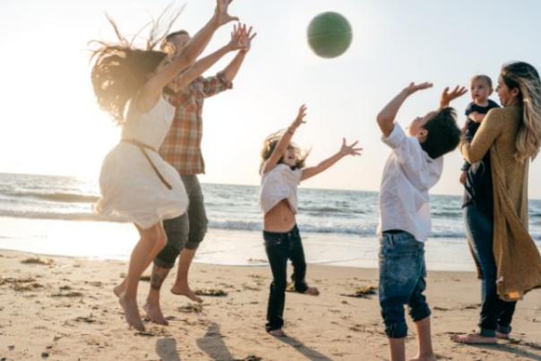family playing ball on the beach