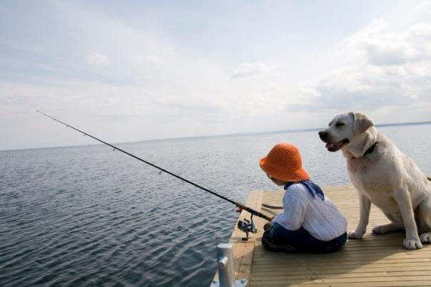 child with fishing rod and dog