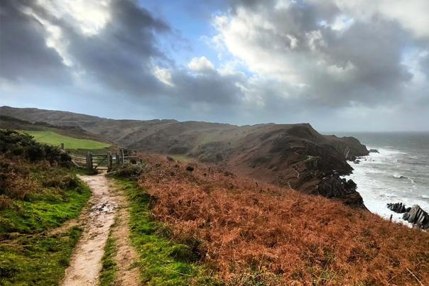 coast of Devon in Autumn, stormy clouds and view of a coastal walking path