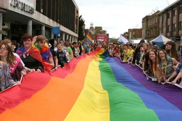 a crowd of people with a rainbow flag