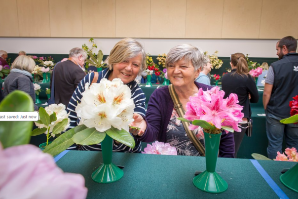 Two ladies admiring white and pink flowers