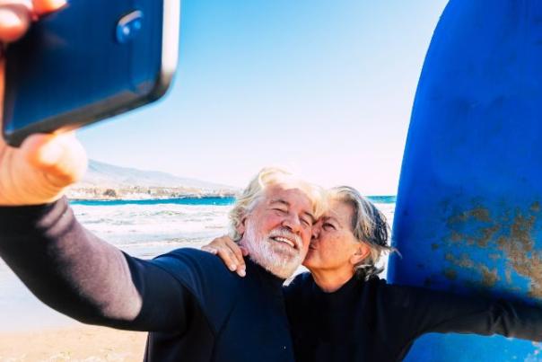 couple taking a selfie with surfboards