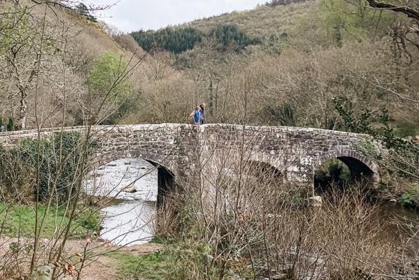 couple walking over a bridge on Dartmoor