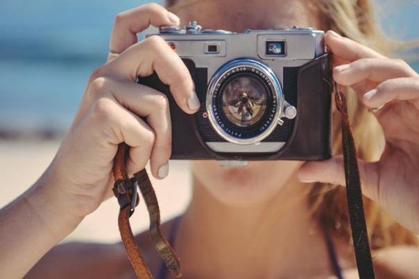 a woman with a camera on the beach