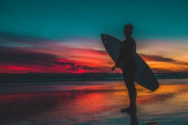 person with surf board against night sky