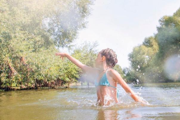 image shows girl swimming in river