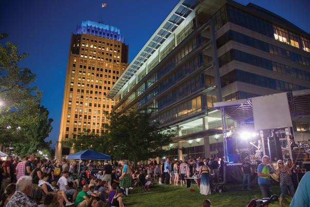 Attendees at Blues, Brews & Barbecue in downtown Allentown, with the PPL Building illuminated in the background.