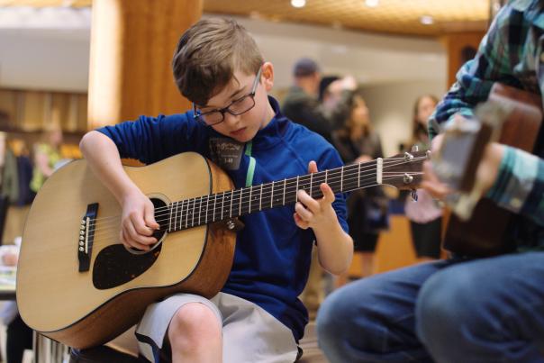 A child plays a Martin guitar