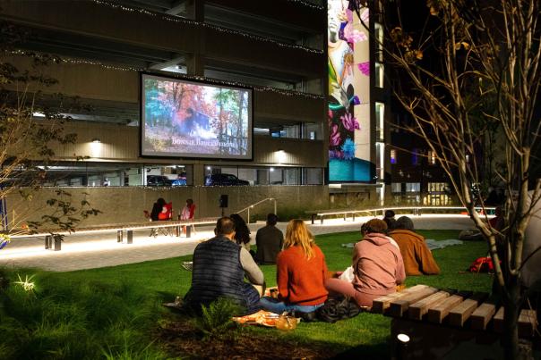 Visitors enjoy a movie on the lawn at the ArtsWalk Pocket Park in Downtown Allentown, PA