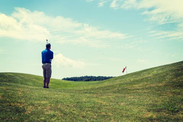 Man hitting a golf ball at the Olde Homestead Golf Club Course