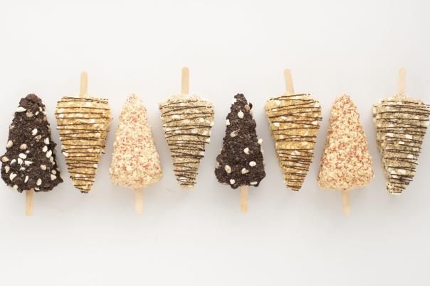 Multiple flavors of cheesecake popsicles dipped in colorful chocolate from Vegan Treats in Bethlehem, PA