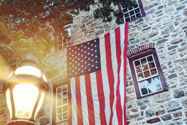 American flags hangs down the historic stone side of the Tavern at the Sun Inn in Bethlehem