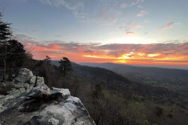 A beautiful sunrise full of orange, pink, and purple hues lights up the sky above Watchtower Overlook at Double Oak Park in Shelby County.