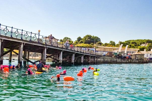 Wild swimmers in the sea near Swanage Pier in Dorset