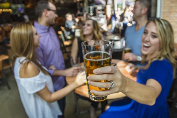 Group of young professionals at RAM Brewery socializing around a table of beers.