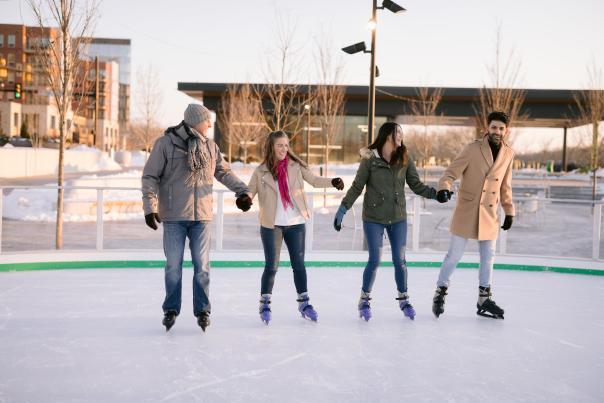 Two couples skating on the rink at Riverside Crossing Park