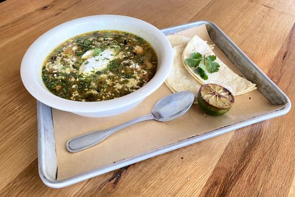 Bowl of green chili with tortillas