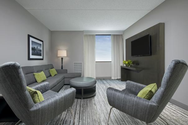 Marriott NW living room with couches, chairs, tables and flat screen.