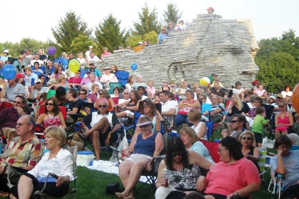 Crowd of people sitting in front of Leatherslips sculpture at Sundays at Scioto concert series.