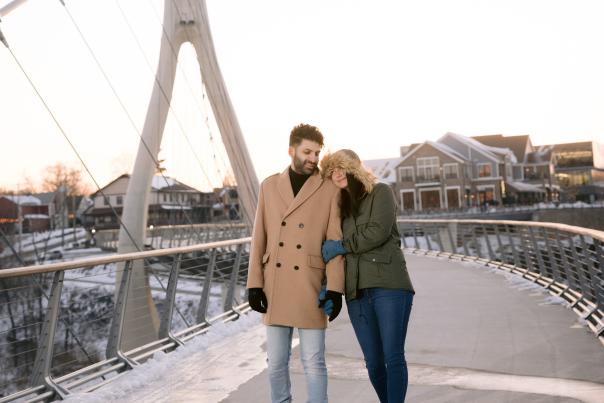 A couple walks hand-in-hand across the Dublin Link Bridge in Dublin, Ohio. The bridge spans the Scioto River, with a unique, modern design.