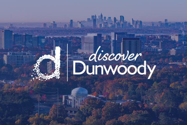 the "discover dunwoody" logo overlays a view of the Dunwoody skyline