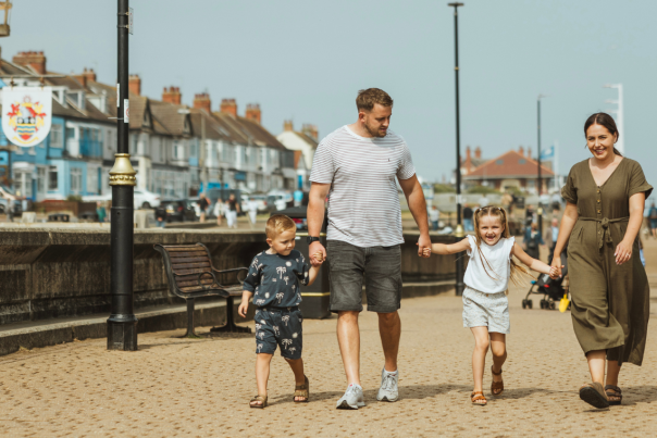 A family walking hand-in-hand along Hornsea's promenade