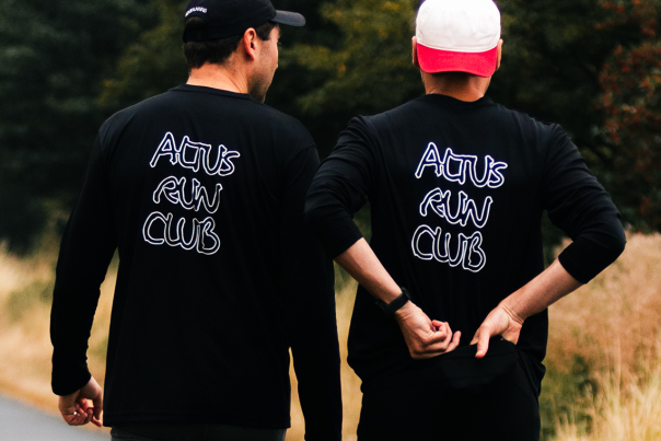 The back of two runners wearing ALTUS run club branded tops in the Yorkshire Wolds.
