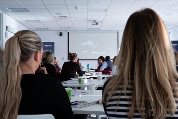 participants of a business workshop, facing the front screen.
