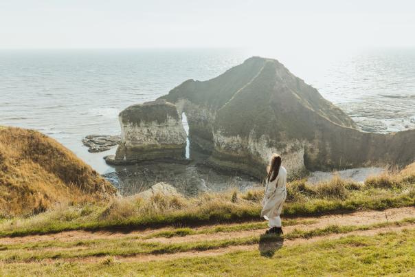 a woman looking out over the drinking dinosaur at Flamborough head