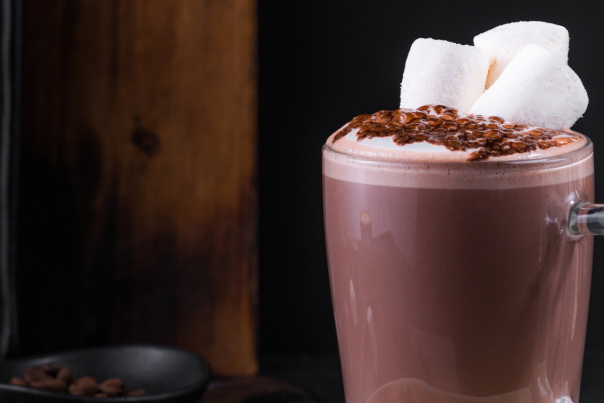 A glass mug filled with hot chocolate and topped with three big marshmallows