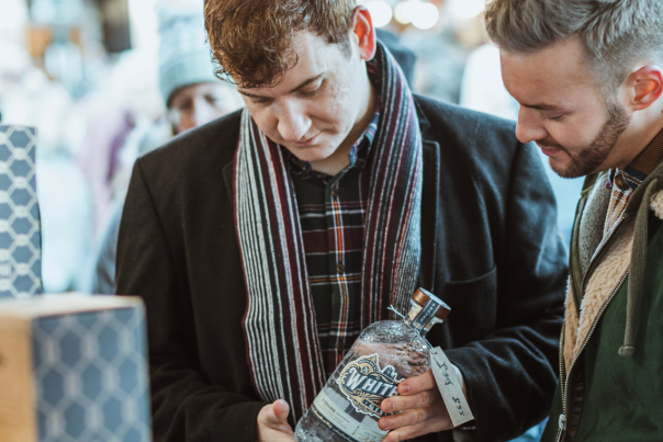 Two men shopping at a drinks stall at the Beverley Festival Christmas
