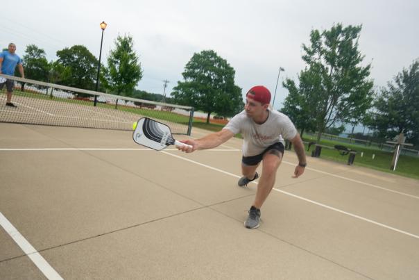 a man hitting a pickleball at the courts at freeman lake