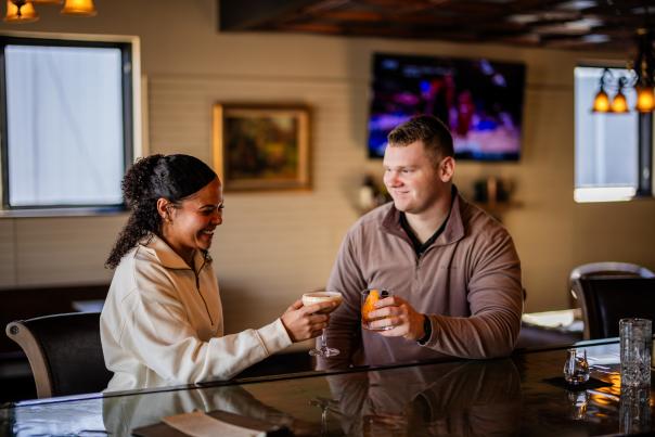 Two people toasting their drinks at Revival Vintage Spirits Bar in Downtown Elizaebethtown, KY.
