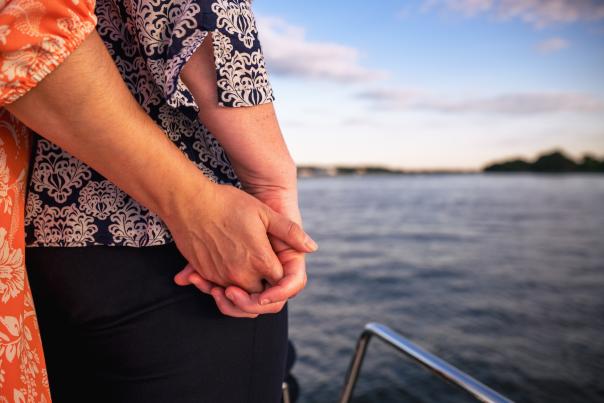 Two Women Lovingly Holding Hands while out boating.