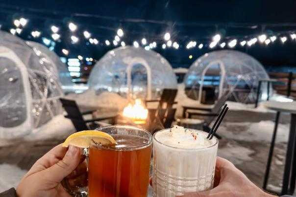 two drinks in front of a fire and igloos on a rooftop in the winter