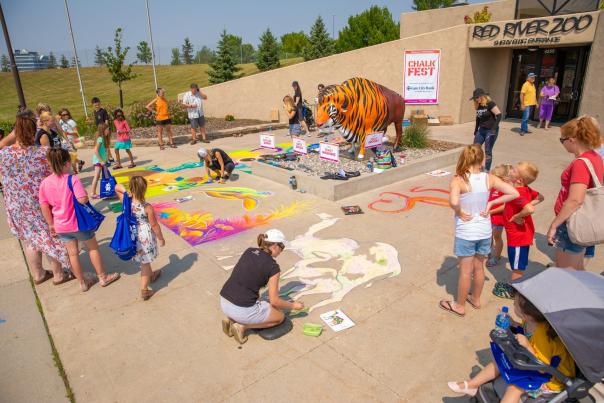 families drawing on sidewalk for chalk fest