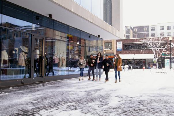 friends walking downtown with coffee in the winter