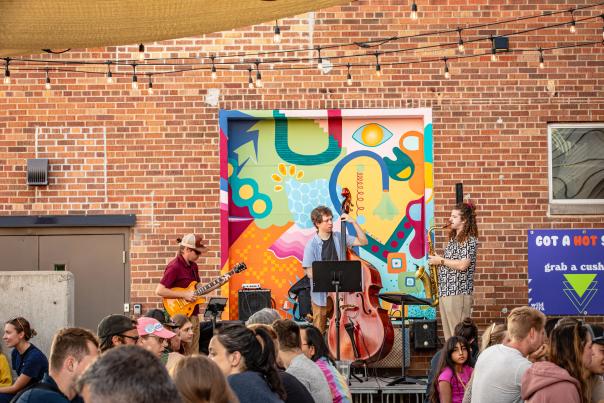 Three people performing jazz music on the Wild Terra patio amongst poeple sitting at picnic tables.