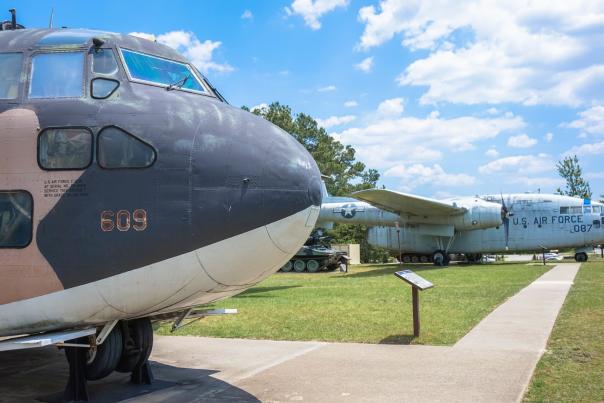 Row of historic military aircraft on outdoor display at the 82nd Airborne Division War Memorial Museum.