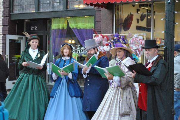 Victorian carolers sing in festive attire during the holiday season in downtown Fayetteville, bringing a nostalgic touch to the city’s Christmas celebrations.