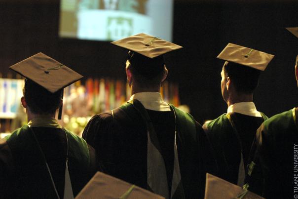 Image of three graduates standing during their ceremony