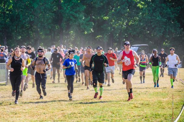 Group of athletes running at the start of an outdoor endurance race in Fayetteville, NC, during a sports and fitness event.