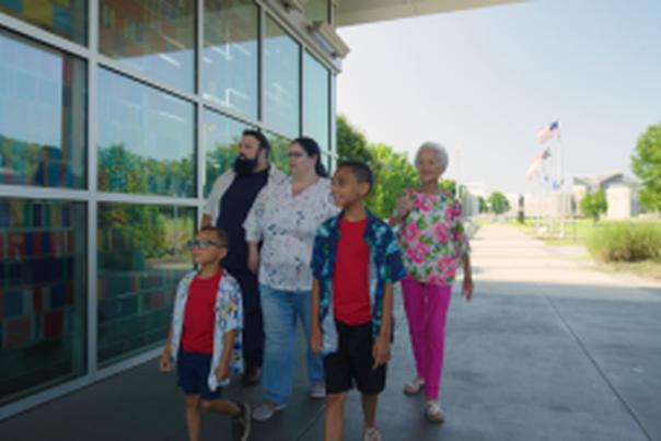 Multi-Generational family visiting Fayetteville's Veterans' Park with the ASOM in the background