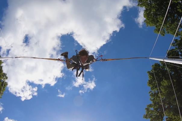 person attached to bungee launch hanging upside down