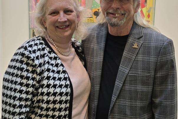 Certified Tourism Ambassadors Lanie Nix-Farver and Mike Farver standing before a painting at the Flint Institute of Arts Museum + Arts School.